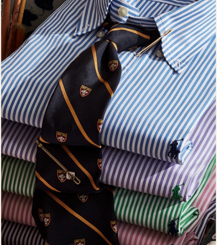 Stack of folded striped button-down shirts with ties.