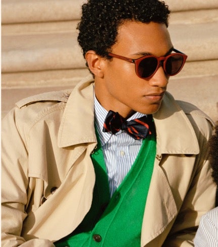 Man in trench coat wears sunglasses.
