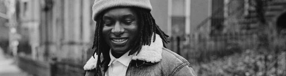 Black-and-white photo of man in shearling-lined jacket and beanie.